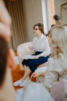 Un thérapeute animant une séance de conseil avec un couple dans un cadre de pièce confortable.