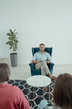 Thérapeute animant une séance de thérapie avec des clients dans un bureau moderne.