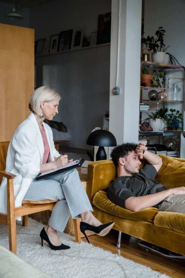 Un conseiller écoute attentivement un patient en détresse dans un environnement de salon moderne.